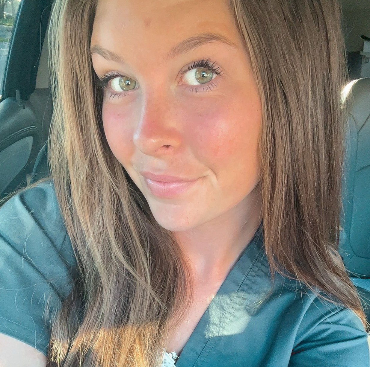 girl wearing scrubs looking at camera