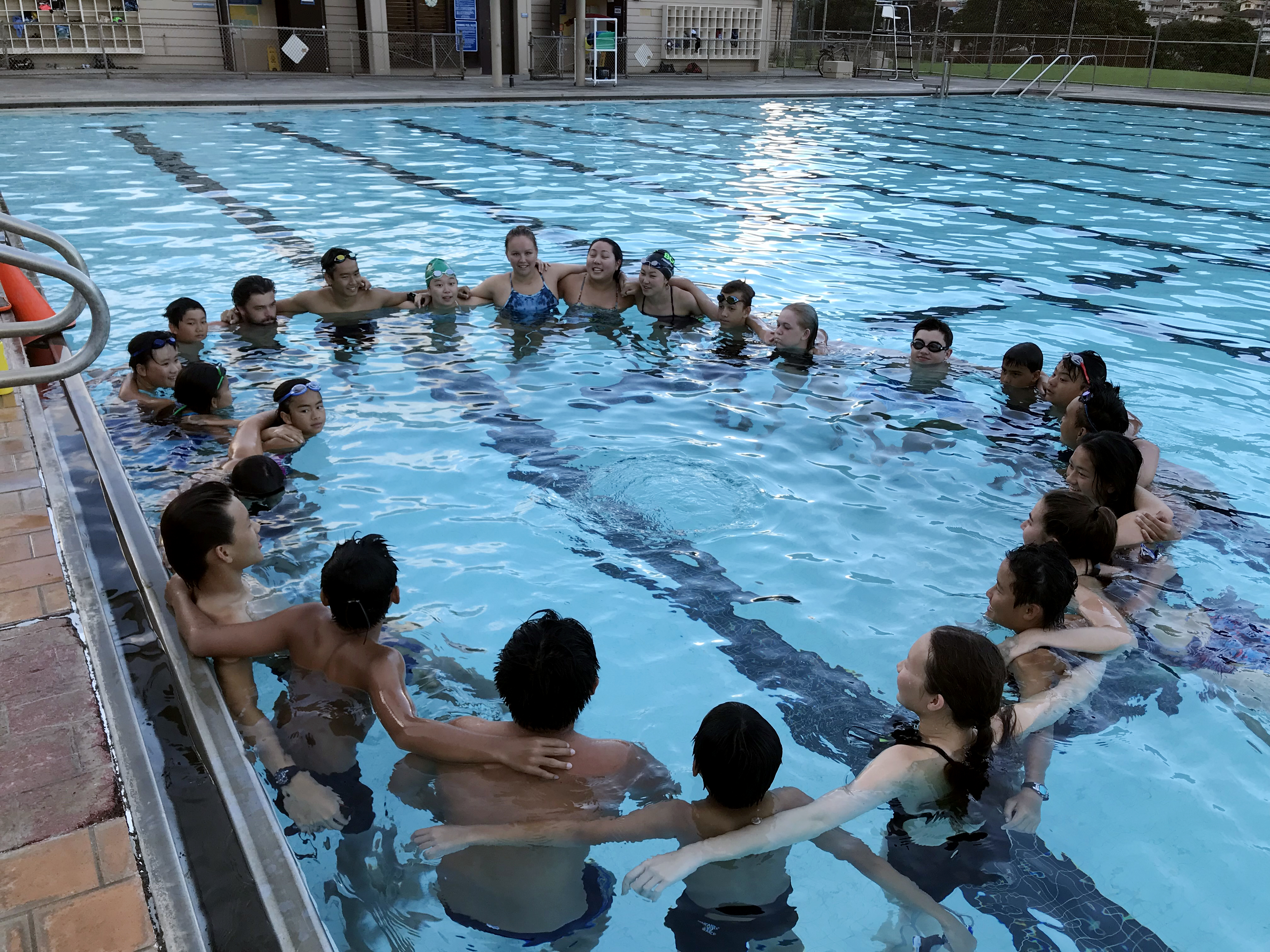 Photo of Rainbow Aquatics swimmers getting ready for a team cheer.