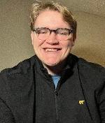 A person wearing glasses smilingAI-generated content may be incorrect.